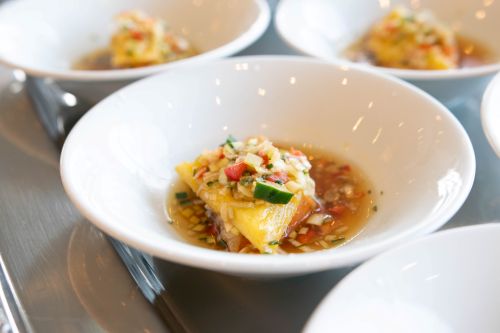 Small white bowls holding bite-sized marinated appetizer pieces in a light sauce, ready to serve as a tasting set.